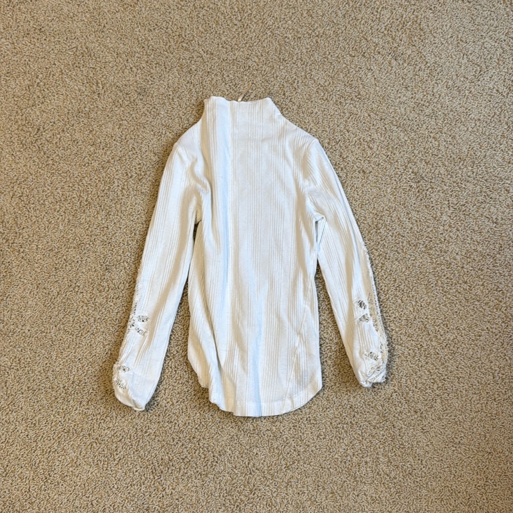 Free People white turtleneck top. Flower crochet detailing on sleeve. Size small
